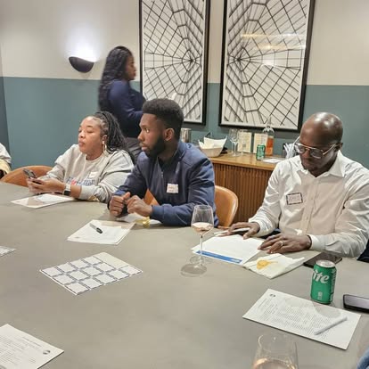 Club members listening and taking notes around a table